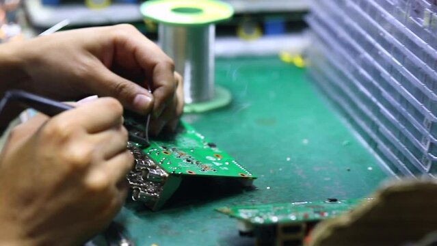 The engineer is soldering the inputs to the motherboard