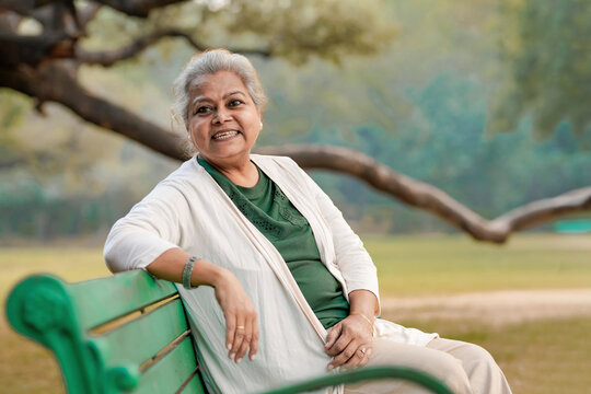 Indian senior woman sitting on bench at park