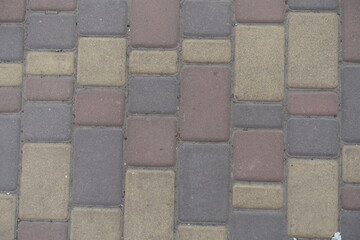 Top view of dusty brown, yellow and pink colored concrete pavers