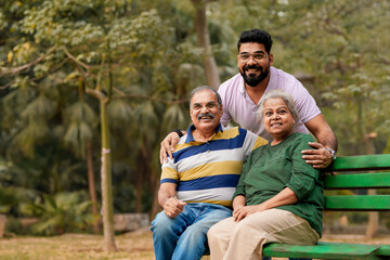 Young Indian man with his parents at park