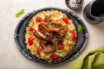Top view of festive plate with slow roasted lamb meat with saffron long rice and vegetables, onion,...