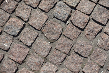 Macro of pavement made of rectangular pink granite stone setts