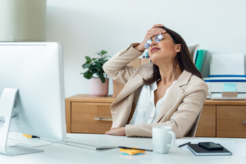 Worried businesswoman working with computer while having problems in the office at home.