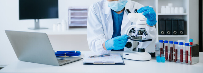 .Young scientists conducting research investigations in a medical laboratory, a researcher in the...