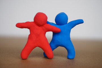 Red and blue plasticine people. Human figures from plasticine sculpture. Concept, friendships, partnerships and relationships between people. Sculting enhance imagination.     