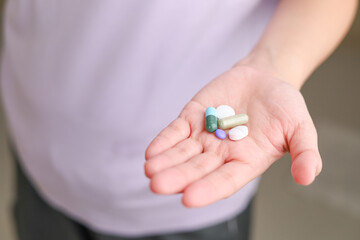 Top view of a lot of pills and tablets in the hand, consuming a lot of pills concept. medicine in old man hand. The concept of medicine, health care, vitamins. background with space for text.