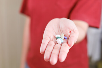 Top view of a lot of pills and tablets in the hand, consuming a lot of pills concept. medicine in old man hand. The concept of medicine, health care, vitamins. background with space for text.