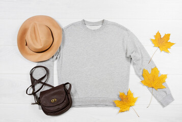 Close up gray blank template sweatshirt hoodie with copy space. Autumn concept yellow leaf. Top...
