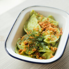 Homemade spinach dumplings with onion crunch