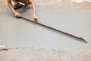 Construction process making of mixer truck freshly. Construction workers leveling concrete pavement.