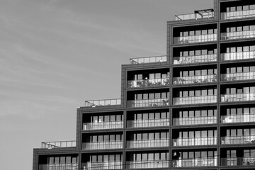 Fotografia uliczna, fragment budynku z balkonami, zdjęcie czarno białe