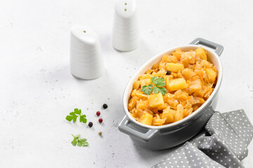 Slow cooker vegetables, stewed cabbage potato in ceramic baking dish. Top view, copy space, flat lay.