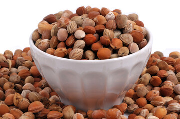 Noyaux de cerises dans un bol avec des noyaux de cerises autour en gros plan sur fond blanc