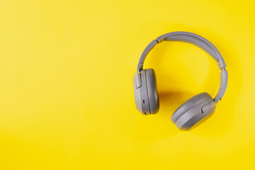 Gray wireless headphones on yellow background , Online learning design concept. Top view of  ,Top view with copy space for text