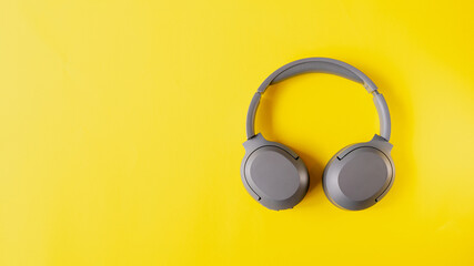 Gray wireless headphones on yellow background , Online learning design concept. Top view of  ,Top view with copy space for text