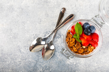 Bowl of granola with yogurt and fresh berries on a texture table. Yogurt berries, acai bowl, spirulina bowl. Healthy food, balanced breakfast. Strawberries, blueberries, kiwi, peach, almonds and chia.