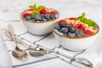 Bowl of granola with yogurt and fresh berries on a texture table. Yogurt berries, acai bowl,...