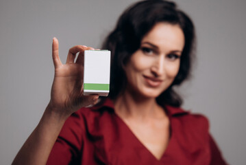 Cosmetologist beautician holds a package with drugs for facial rejuvenation. A female doctor in office shows treatment options. Mockup with copy space
