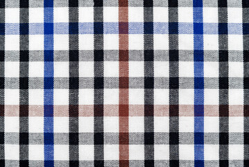 The texture of linen fabric in a large cell of black, blue and white. Scottish tailoring material. checkered fabric