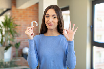 feeling happy, showing approval with okay gesture. dental retainer concept