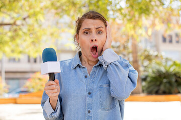young pretty woman feeling extremely shocked and surprised. presenter and microphone concept