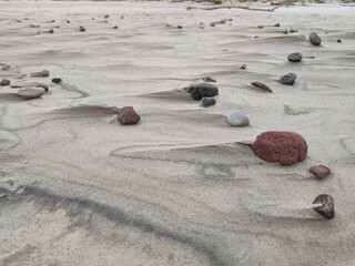Beach sand with stones in the wind with strange shapes