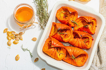 Oven baked pumpkin slices with honey, rosemary and seeds. Vegan food, trendy hard light, dark shadow