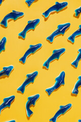 Blue gummy sharks, sweet candies isolated on yellow background
