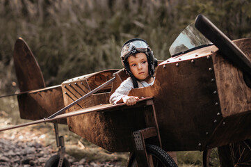 A young boy aviator in a homemade airplane in a natural landscape Authentic mood of the picture....
