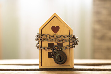 The house is chained and padlocked and stands on a wooden board, the concept of a ban on the sale of real estate, house