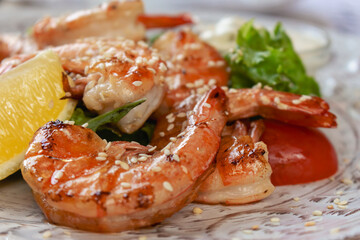 Shrimps with lemon and salad. Seafood close up. Served fish dish. Fish restaurant menu. Fried prawns with lemon. Mediterranean mollusk plate. Flat lay photo. 