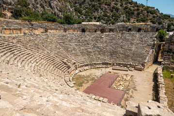 The ruins of the amphitheater and ancient rock tombs in the ancient city of Myra in Demre, Turkey
