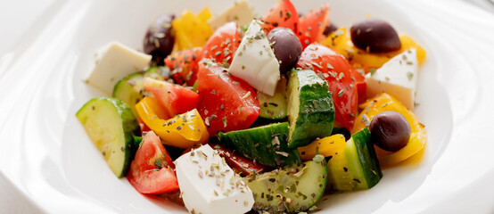Classic Greek salad. Salad with tomatoes, cucumbers, red pepper, olives, oregano and feta cheese. Close-up. Banner image for design, web site