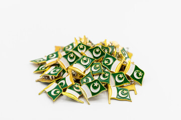 Pakistan flag badges pile closeup with selective focus on white isolated background