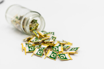 Pakistan flag badges in a bottle on white isolated background. selective focus