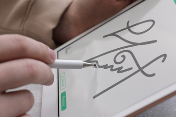Electronic signature. Man using stylus and tablet, closeup