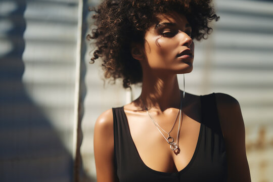 Beautiful ebony female model in black dress with sun stripes.	