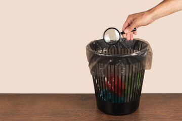 throw a magnifying glass in a trash can, magnifier in hand in front of a trash can, bad search...