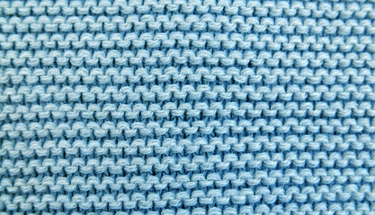 Close up background of knitted blue wool fabric knitwear texture.

