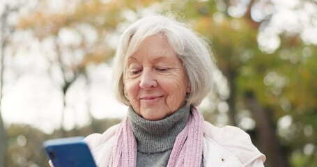 Phone, social media and a senior woman in the park, typing or reading a text message for communication. Mobile, contact and sms with a happy elderly female person walking in an outdoor garden - Powered by Adobe