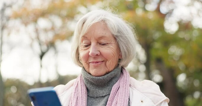 Phone, social media and a senior woman in the park, typing or reading a text message for communication. Mobile, contact and sms with a happy elderly female person walking in an outdoor garden