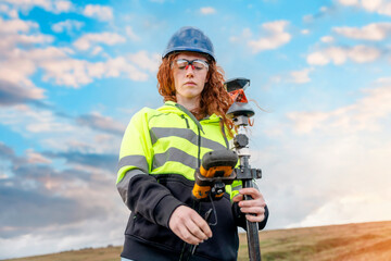 Female Woman land surveyor working with moder surveying geodesic instrument tachometer checking...