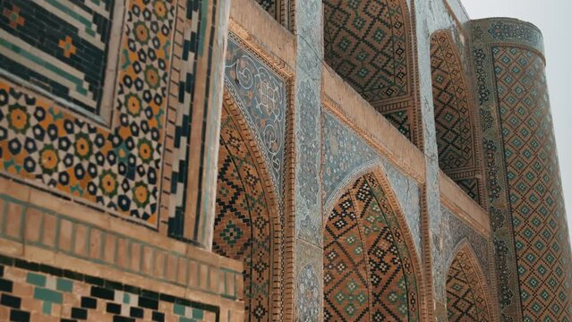 Medieval oriental architecture, Beautiful Patterned Wall. Amazing facade covered by glazed mosaic tiles. Bukhara is a popular tourist attraction of Central Asia. Uzbekistan. High quality 4k footage
