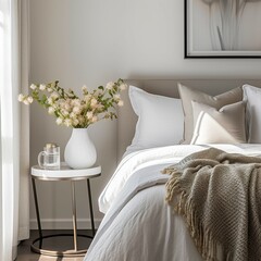 A close-up of a clean modern bedroom decorated with linens with luxurious soft white blankets with delicate natural light. 