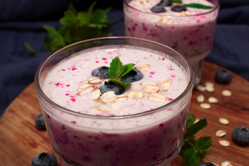 Homemade blueberry smoothie with mint on a blue fabric background. Detox diet