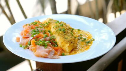 Smoked salmon and onion omelette. Culinary breakfast dish with fresh fish and vegetables on plate. Hotel breakfast cuisine.