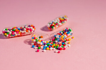 Medical pill capsules filled with colorful sugar sprinkles. Health concept