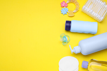 Flat lay composition with baby care products and accessories on yellow background, space for text