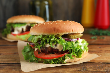 Delicious burger with beef patty and lettuce on wooden table