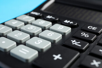 Fototapeta premium Calculator on light blue background, closeup. Office equipment